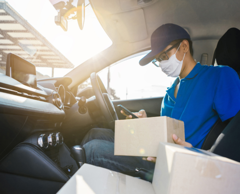 Side view of man in mask doing delivery